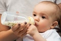 Close up of mother feeding baby with milk formula