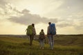 Family with backpacks. Tourists standing in nature hikking at evening in evening. Back view.