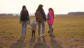 Family with backpacks travels with a dog. teamwork of a close-knit family. mother, daughters and home pets tourists Royalty Free Stock Photo