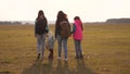 Family with backpacks travels with a dog. teamwork of a close-knit family. mother, daughters and home pets tourists