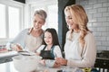 Family, baking and cooking together in a home kitchen with mother, grandmother and child learning about food and being a Royalty Free Stock Photo