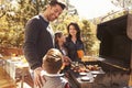 Family barbecuing on a deck in the forest