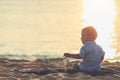 Family on the beach concept, Caucasian boy siting and holding sa Royalty Free Stock Photo