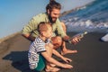 Father and son on the beach with message in a bottle. Royalty Free Stock Photo