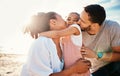 Family, beach and parents kiss child with travel and bonding, love and happiness together outdoor. Tropical vacation Royalty Free Stock Photo