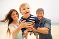 Family, beach and smile of baby with parents, mother and father together with little boy for love. Holiday, mom and dad Royalty Free Stock Photo