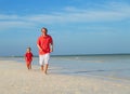 family beach vacation -father and son run at sea