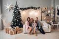 Family in beautiful room decorated for Christmas.