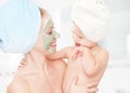 Family beauty treatment in the bathroom. mother and daughter baby girl make a mask for face skin