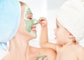 Family beauty treatment in bathroom. mother and daughter baby girl make mask for face skin Royalty Free Stock Photo