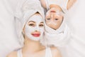 Family beauty treatment in the bathroom. Pretty mother and little two year old daughter with wrapped hair in towels