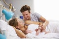 Family In Bed Holding Sleeping Newborn Baby Daughter Royalty Free Stock Photo