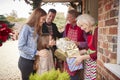 Family Being Greeted By Grandparents As They Arrive For Visit On Christmas Day With Gifts Royalty Free Stock Photo