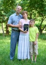 Family with a Bible in his hand, man with woman and child, three people in city park Royalty Free Stock Photo