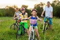 Family on bicycles on the grass field