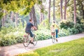 Family on bicycles in park- little Boy on bike with mother and father Royalty Free Stock Photo