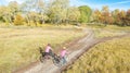 Family on bikes autumn cycling outdoors, active mother and kid on bicycles, aerial view of happy family with child in fall park Royalty Free Stock Photo