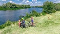 Family on bikes cycling outdoors, active parents and kids on bicycles, aerial top view of happy family with children