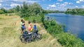 Family on bikes cycling outdoors, active parents and kids on bicycles, aerial view of happy family with children relaxing