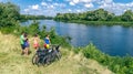 Family on bikes cycling outdoors, active parents and kids on bicycles, aerial view of happy family with children relaxing