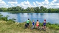 Family on bikes cycling outdoors, active parents and kids on bicycles, aerial view of happy family with children relaxing