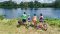 Family on bikes cycling outdoors, active parents and kids on bicycles, aerial view of happy family with children relaxing Royalty Free Stock Photo