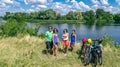 Family on bikes cycling outdoors, active parents and kids on bicycles, aerial view of happy family with children relaxing