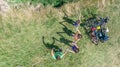 Family on bikes cycling outdoors, active parents and kids on bicycles, aerial view of happy family with children relaxing