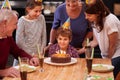 Family, birthday cake and smile of boy, parents and grandparents together with youth and candles. Happy, kid and dessert Royalty Free Stock Photo