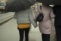 Family with black umbrellas. People rain. Parents with their daughter walk around the city