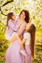 A family in a blossoming spring garden. Happy mom and two daughters. Royalty Free Stock Photo