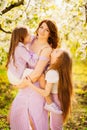 A family in a blossoming spring garden. Happy mom and two daughters. Royalty Free Stock Photo