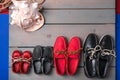 Family boat shoes on wooden background. Four pair of red and black grey desk with rope shell. Top view, copy space