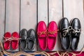 Family boat shoes on wooden background, Four pair of red and black boat shoes