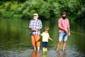 Family bonding. Grandfather, father and grandson fishing together. Little boy on a lake with his father and grandfather. Royalty Free Stock Photo