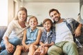 Family bonding time is the best. a happy family of four relaxing together on the sofa at home. Royalty Free Stock Photo