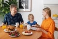 family breakfast. parents and child eating by the table at home kitchen in the morning Royalty Free Stock Photo