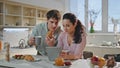 Family breakfasting looking tablet at kitchen. Couple surfing internet at home Royalty Free Stock Photo