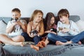 Family, brothers and sisters are sitting at home on gray sofa and holding several puppies on their hands and knees. Royalty Free Stock Photo