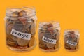 French family budget concept with jars full of coins close up on yellow background Royalty Free Stock Photo