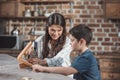 Little boy and his beautiful mother using hammer to build a