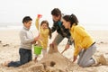 Family Building Sandcastle On Winter Beach Royalty Free Stock Photo