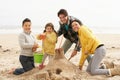 Family Building Sandcastle On Winter Beach Royalty Free Stock Photo