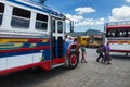 Family in a bus terminal with colorful buses in Antigua, Guatemala