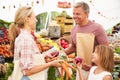 Family Buying Fresh Vegetables At Farmers Market Stall Royalty Free Stock Photo