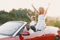 Family in a cabriolet convertible car at the sunset Royalty Free Stock Photo