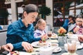 Family in a cafe - mother with daughters eating pavlova cake Royalty Free Stock Photo