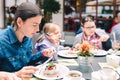 Family in a cafe - mother with daughters eating pavlova cake Royalty Free Stock Photo