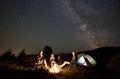 Family beside camp, campfire, tent under night starry sky Royalty Free Stock Photo