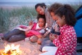 Family Camping On Beach And Toasting Marshmallows